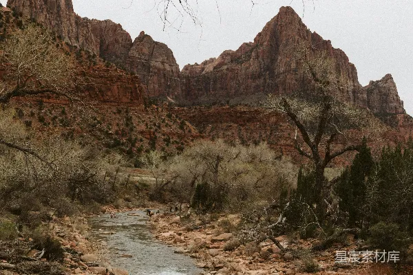 高清摄影 一条河流穿越沙漠景观，背景是山峦。