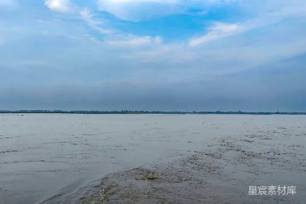 高清摄影 天空下一条宽广的河流，有蓝色的斑点。