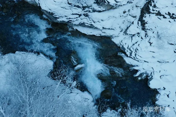 高清摄影 一条河流流经被白雪覆盖的山侧