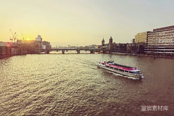 高清摄影 一艘船沿着河边行驶，旁边是高大的建筑物