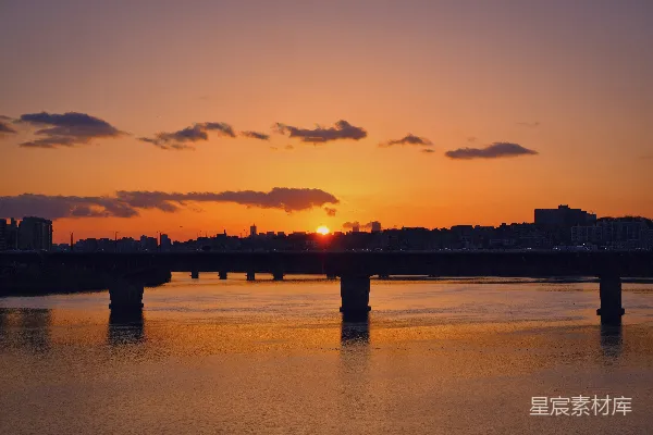 高清摄影 夕阳下桥的剪影映在水面上