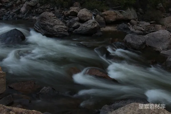 高清摄影 一条河流，河中有岩石和水流过。