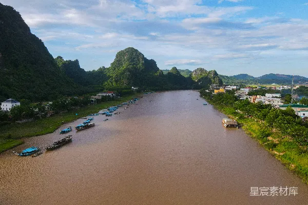 高清摄影 棕色河流流过绿色的喀斯特山峦，船儿在其中航行。
