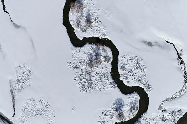 高清摄影 一条蜿蜒的河流流经一片覆有白雪的景观之中。