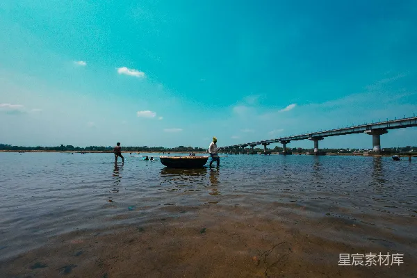 高清摄影 两人拉动小船穿过一条浅水河。