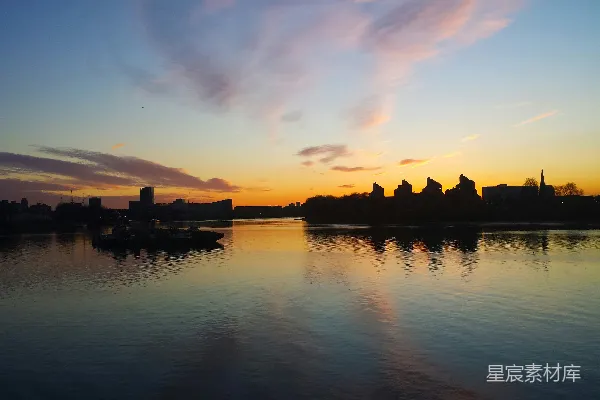 高清摄影 夕阳映照在一片水域之上，城廓隐约可见于背景中。
