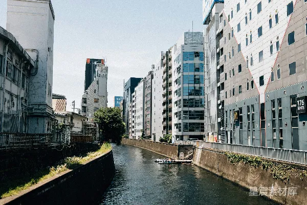 高清摄影 一条狭窄的运河夹在现代建筑和旧结构之间流淌。