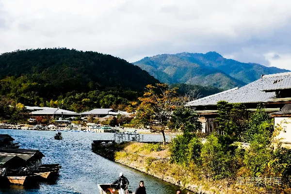 高清摄影 白天河边一白一蓝的船附近有绿树和山。