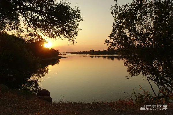 高清摄影 一圈树木围绕的水域和夕阳
