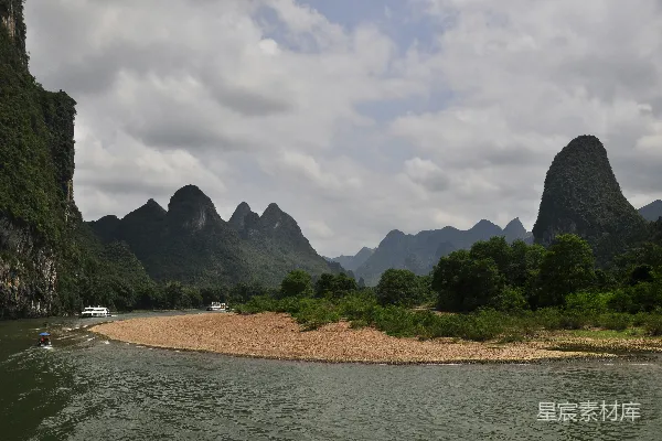 高清摄影 河面上的一条小船，背景是山脉。