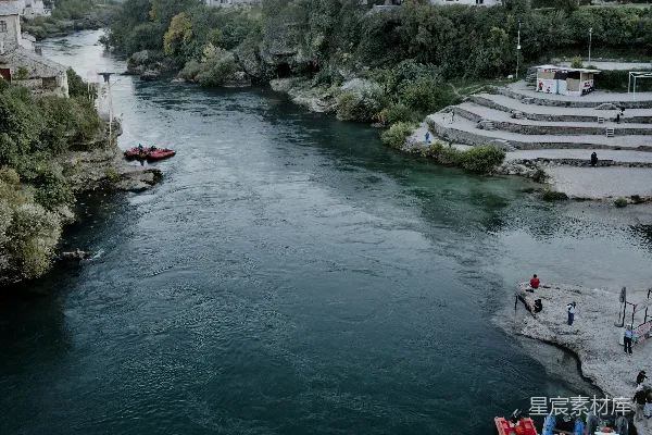 高清摄影 一条河流流经一座有白建筑和山的城镇。