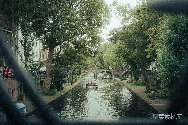 高清摄影 一艘船沿着河边行驶，旁边是高大的建筑物