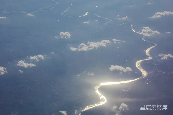 高清摄影 河面上空的俯视景象，阳光透过云层在蜿蜒的小河上反射。