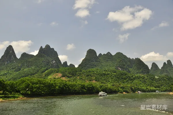 高清摄影 一艘船顺着河流行驶，周围被山峦环绕。