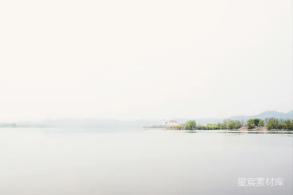 高清摄影 远处树木和建筑环绕的宁静湖泊。