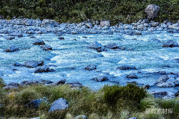 高清摄影 一条岩石嶙峋的小河流淌在草木丛生的山地景观中。