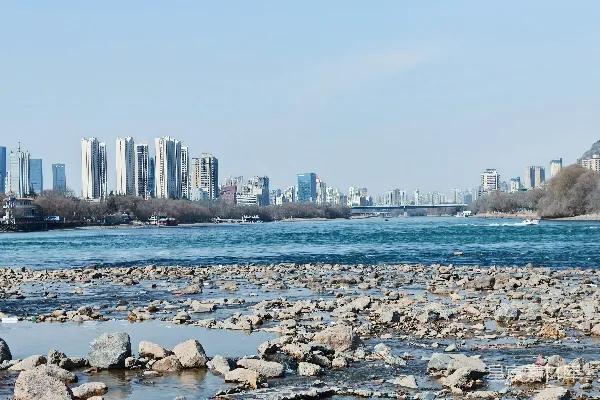 高清摄影 远处城市 skyline 辐射着一条岩石河床
