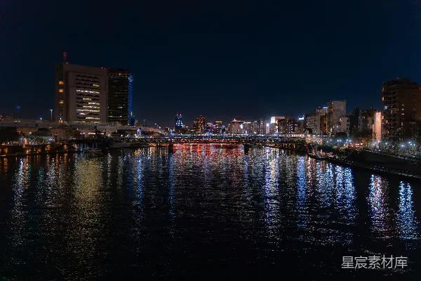 高清摄影 河面上的夜景，桥在背景中。