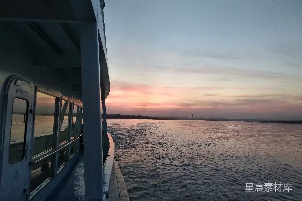 高清摄影 夕阳下，一艘船正顺着河流前行。