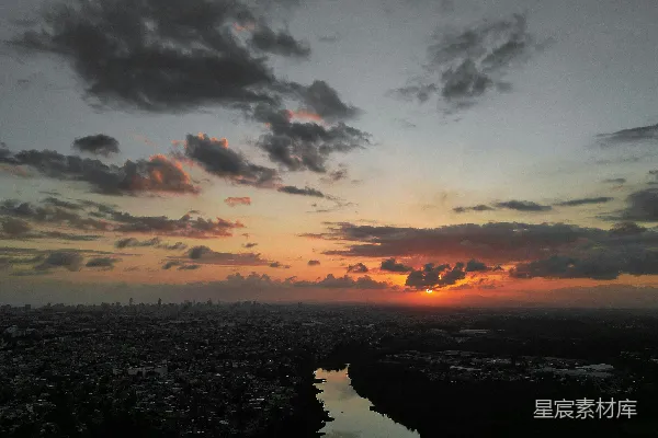 高清摄影 夕阳落下在一座城市和一片水域之上