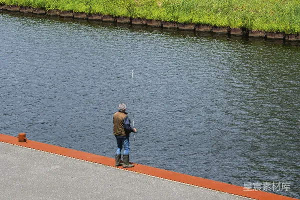 高清摄影 身穿灰色长袖衫和蓝色牛仔裤的男人站在混凝土码头上，白天拍摄。