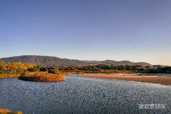 高清摄影 河岸晚霞中流淌的平静河流。