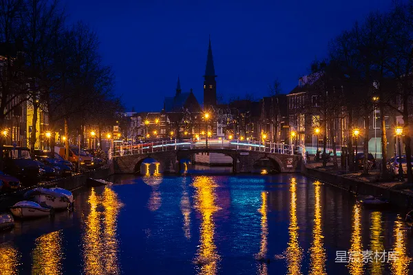 高清摄影 夜晚桥上横跨宁静河流，有照明的街道灯亮起。