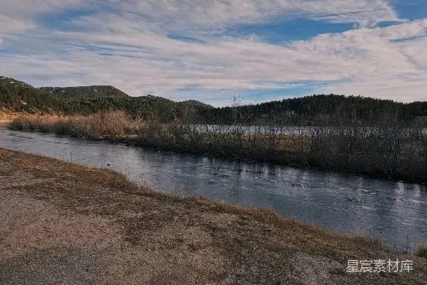 高清摄影 平静的河流穿过一个有山和树的景观。