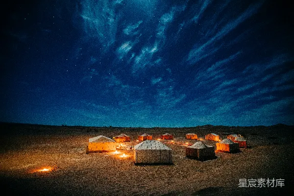 高清摄影 夜晚白棕帐篷坐落在棕色田野上，天空是蓝色的。