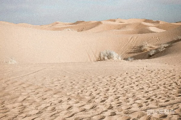 高清摄影 远处有一座棕色的山丘，旁边是带状的棕色沙地。