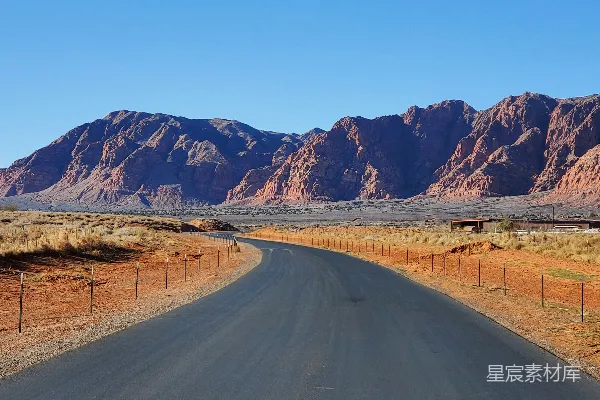 高清摄影 沙漠中一条路，背景是山峦。