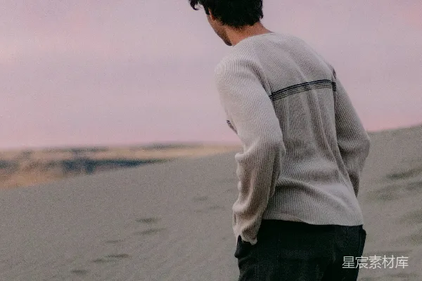 高清摄影 一个男人站在一片沙子海滩的顶端。