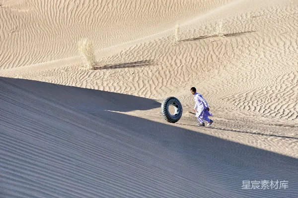 高清摄影 一个男人走在一条沙地旁边的小路上