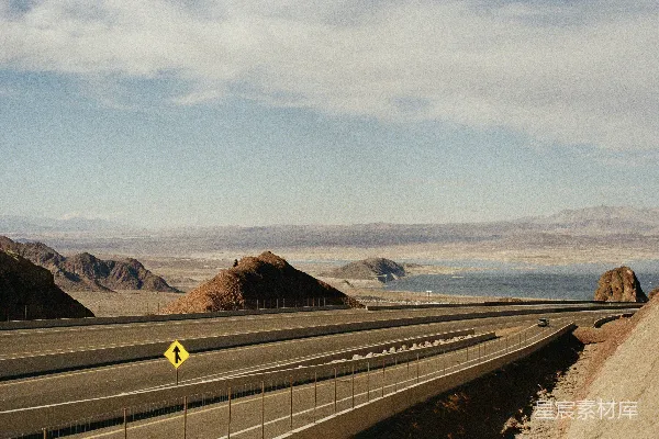 高清摄影 一条与山峦相连的道路和远处的水域