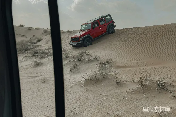 高清摄影 一辆红色的卡车在沙地里行驶。