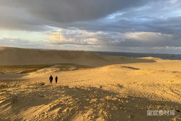 高清摄影 几个行人穿过一片沙地