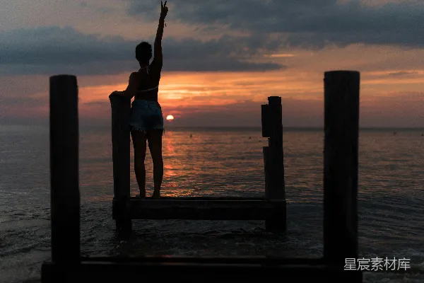 高清摄影 女士站在棕色木制码头上举起她右手，在金时分
