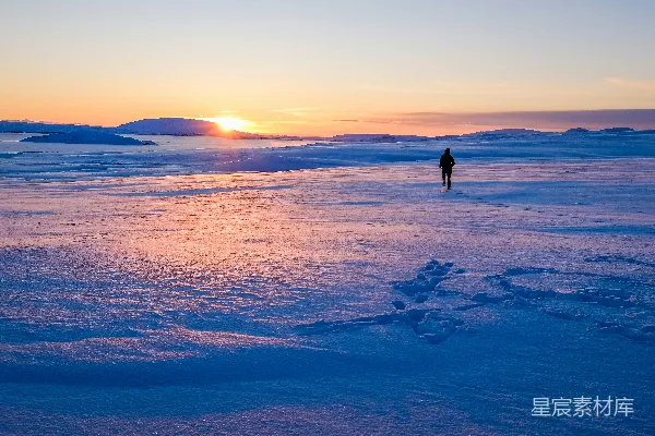 高清摄影 人在雪地上行走，迎着日出。
