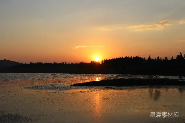 高清摄影 夕阳下树木近处水面的轮廓