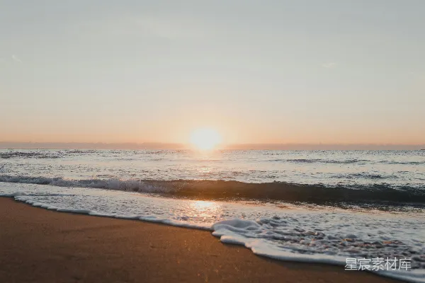 高清摄影 有波浪的海滩，在背景中是太阳。