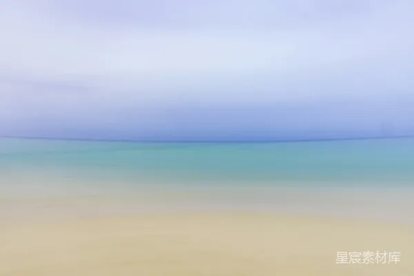 高清摄影 一幅模糊的海滩照片，水是蓝色的。