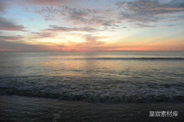 高清摄影 海滩上的太阳正在 Setting 落下到水面上方。