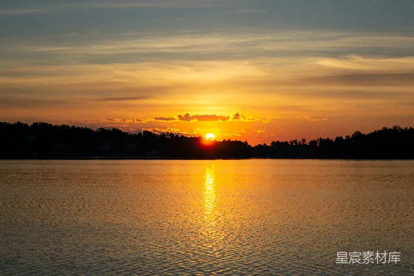 高清摄影 夕阳西下，落在一片水域之上
