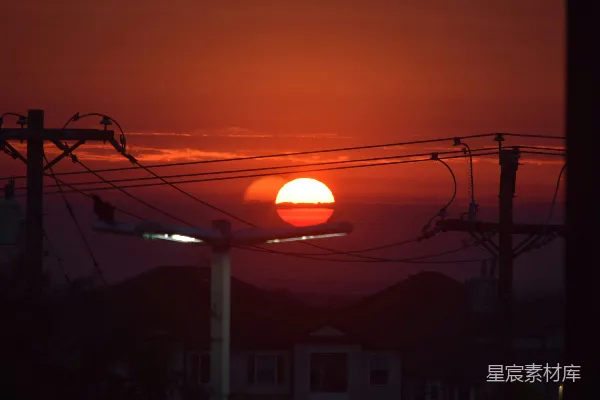 高清摄影 日落西山，背后是电线杆和电话线。
