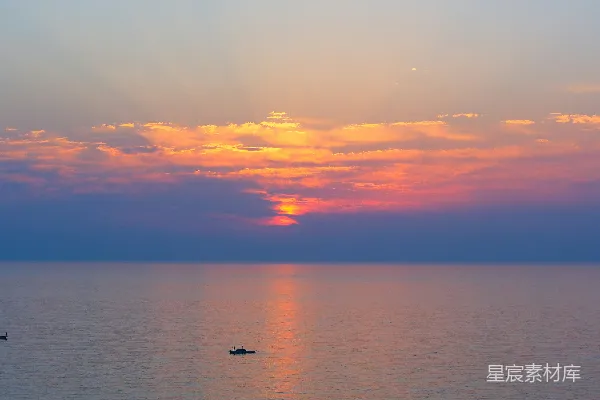 高清摄影 夕阳下的平静海面与小船