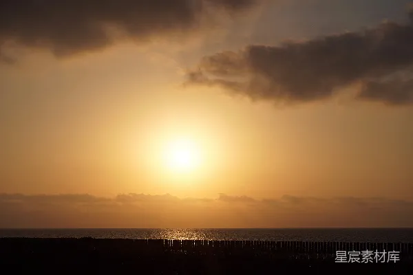 高清摄影 在阴天的一天，太阳正沉落在海面上。