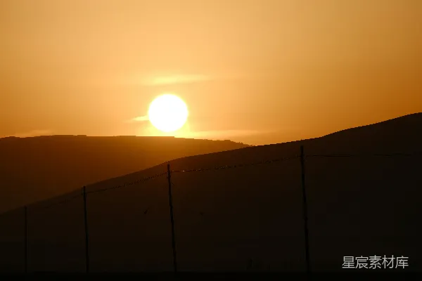 高清摄影 沙漠里太阳落在一堵围栏后面。
