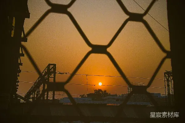 高清摄影 夕阳落在一道铁丝网后面