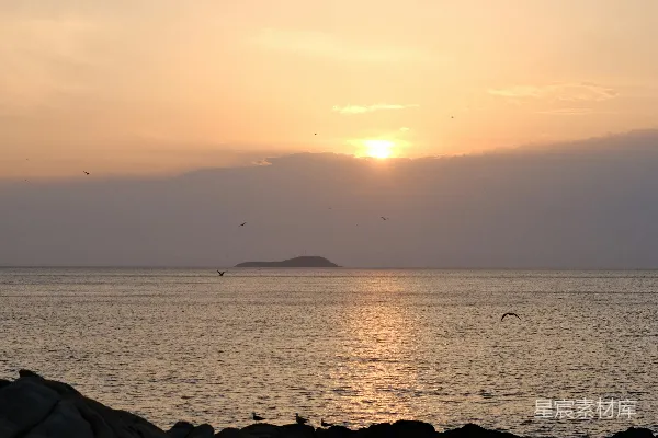 高清摄影 夕阳西下，落在海边的一片岩石上。