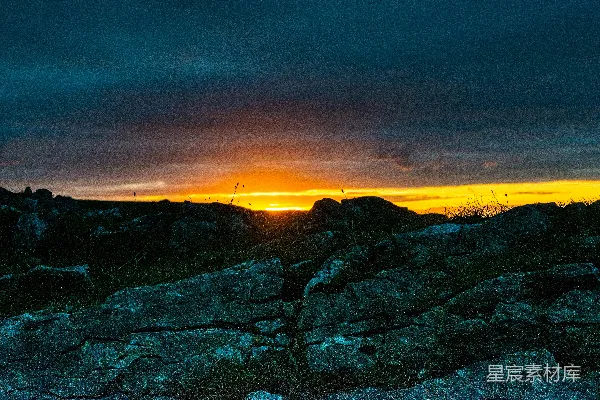 高清摄影 夕阳照耀在一片岩石山坡之上